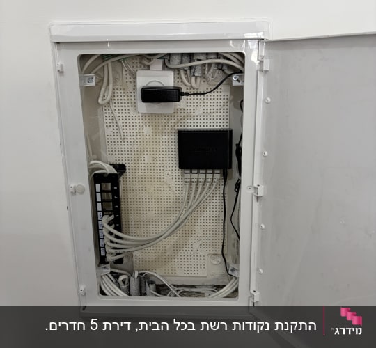 ארון תקשורת ביתי פתוח עם מתג רשת וחיבורי כבלים מסודרים